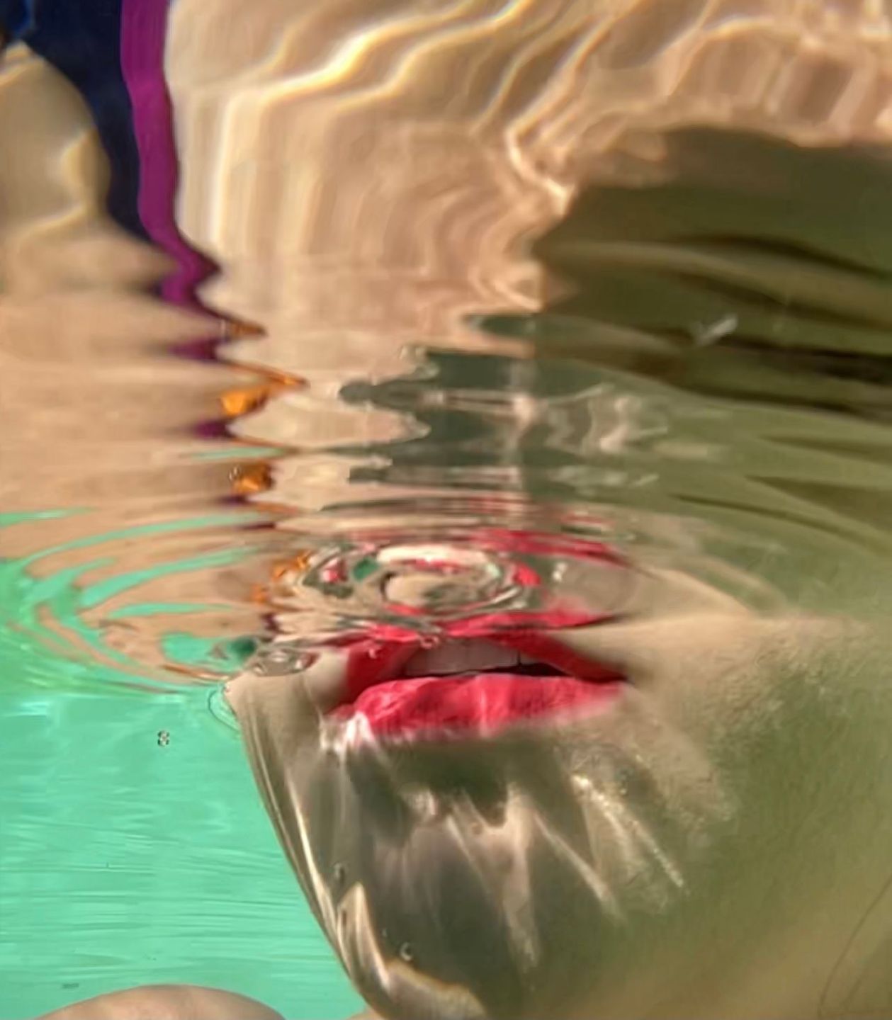 Abstract underwater image of red lips seen through rippling water