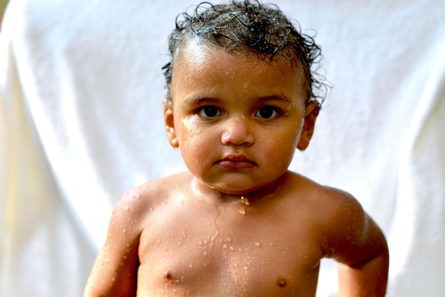 Wide-eyed toddler fresh from the bath