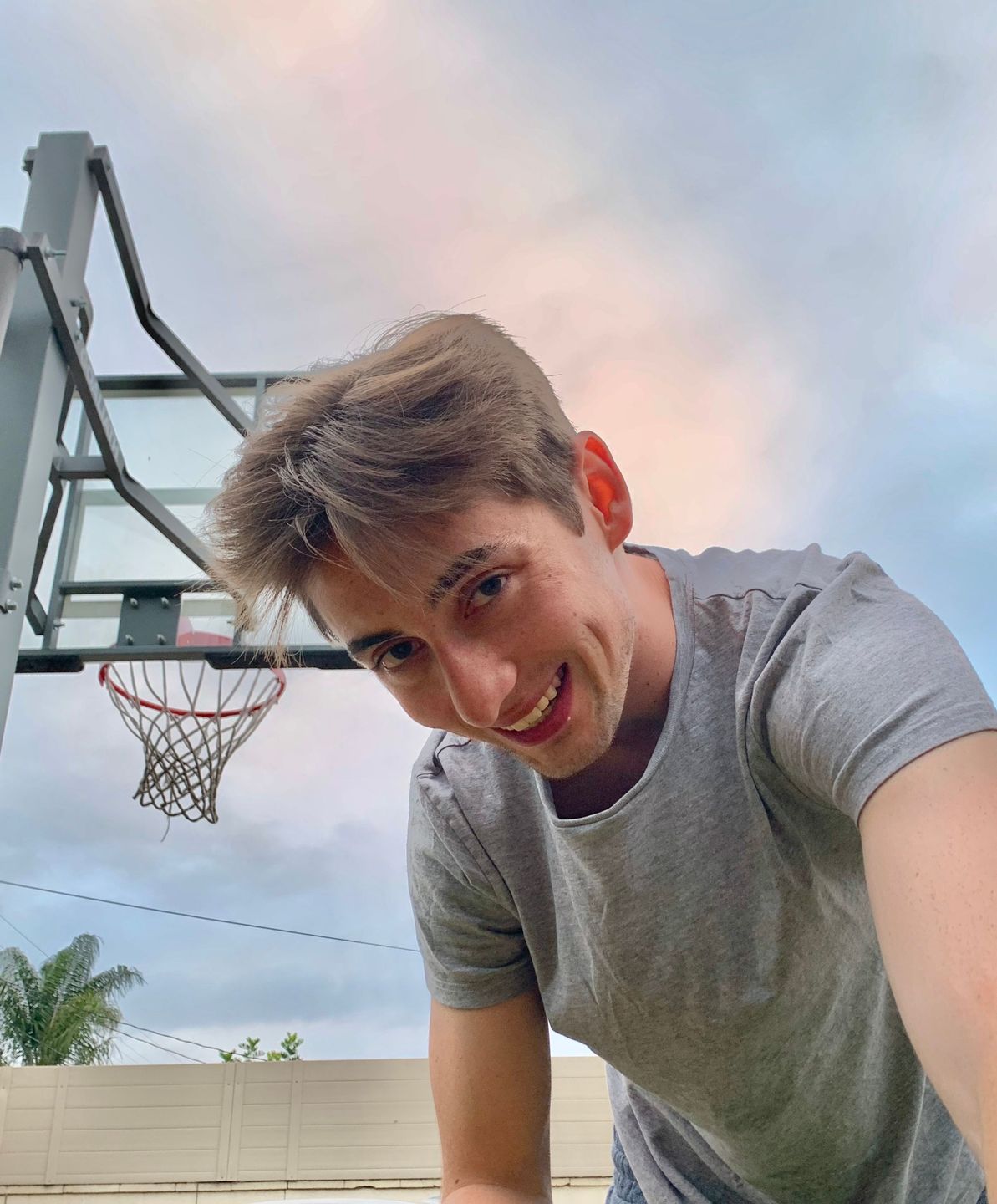Casual golden-hour portrait of a teenager at a basketball court
