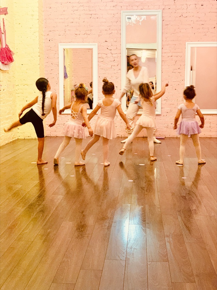 Young ballet dancers rehearsing in a sunlit studio