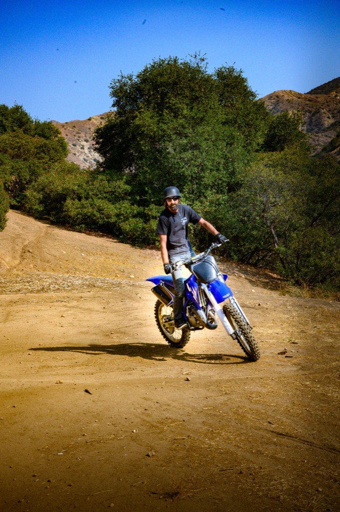 Motocross rider photographed mid-ride on a dirt trail